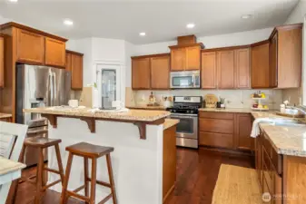View of the kitchen from the back door. Bar height counter, walk-in pantry, and plenty of cabinetry make this kitchen a dream!