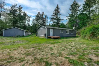 Backyard with single door access with 3 step back deck
