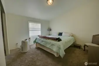 Primary bedroom with wall-to-wall carpet and en-suite bathroom and large closet.