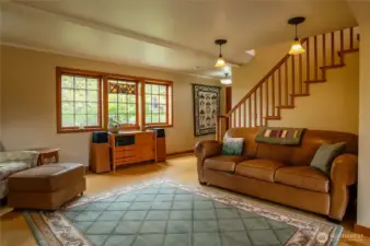 Main house floor 1 living area with bamboo flooring, foyer in background, stairway to bedrooms