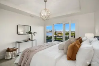 Lower-level primary bedroom features high ceilings, designer lighting and expansive balcony with amazing views!