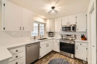 The remodeled kitchen impresses with stainless steel appliances, a new oven, quartz countertops and backsplash.