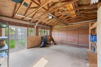 A view of the inside of the garage with doors to the yard. Garage is accessible from the alley.