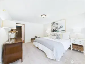 Spacious primary bedroom looks out to the backyard.