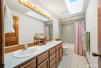 Full bathroom with double sinks and shower and bathtub.