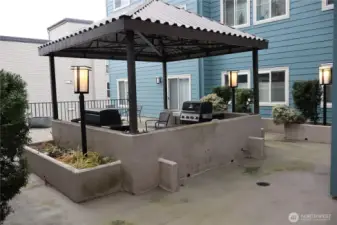 The outdoor space features a large patio and a covered barbeque area.