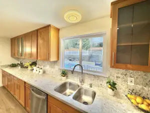 Practical dual sinks with brand new dishwasher conveniently located adjacent. Enjoy stunning views of the swimming pool and spacious backyard through the kitchen window.