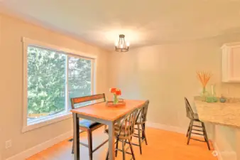 Dining room off kitchen with large picture window facing wooded backyard