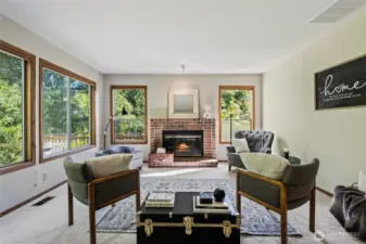 Seating arrangements galore in family room with fireplace.