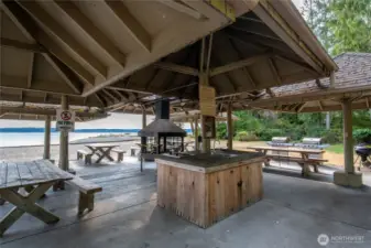 Covered beach side entertainment includes centeral fireplace, sink, and multiple cooking options