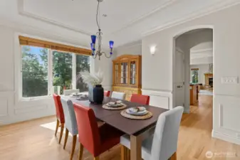 Formal dining room with architectural detailing, hardwood floors, and seamless flow for hosting elegant gatherings.