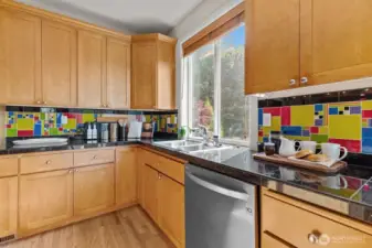 Bright kitchen workspace with large windows, tile backsplash, and functional layout designed for everyday living.
