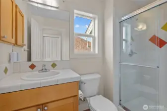 Bright full bathroom with tub/shower combo and natural light.