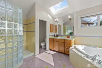 Spa-inspired bathroom with soaking tub, skylight, and glass block shower wall.