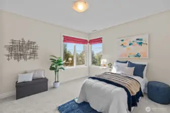 Sunlit bedroom with large windows and serene neighborhood views.