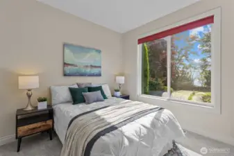 Bright bedroom with oversized window framing peaceful outdoor views.