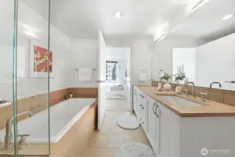 A luxury bathroom featuring a double sink, full-size soaking tub, and walk-in shower.