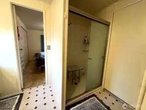 Large shower with mounted shower bench.