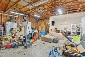 Interior of Garage and Shop Space. There is a Storage Room to the Back Left and Office/TV Room to the Back Right.