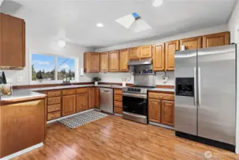 SS appliances and warm wood flooring