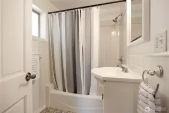 Main floor guest bath with beautiful tile.