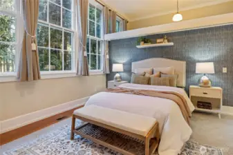 Walk in closet behind bed wall.