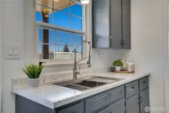 A window over the double-basin stainless sink looks out to the back yard.