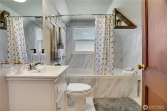 The 2nd full bath is freshly renovated with new flooring, tub, tile surround, and vanity. This large tub is meant for soaking! A privacy glass window allows for light and additional air flow.