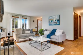Set at the heart of the home, the living room connects to the dining area and the hall. The door on the right leads down to the basement.