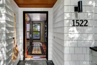 A sheltered entry opens with a modern welcome, framing a first hint of Portage Bay beyond the trees. From the moment you step inside, Olmsted’s landscape becomes the quiet backdrop to daily life.