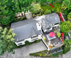Tucked within Interlaken Park, the residence sits in rare seclusion on a private lane while embracing treetop outlooks in every direction. From above, the home reveals its balance of contemporary design, generous outdoor living, and woodland privacy at the heart of North Capitol Hill.