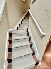 Beautiful Laminate hardwood stairs with carpet runner.