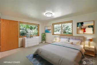 Primary bedroom with nature's masterpiece out all windows.