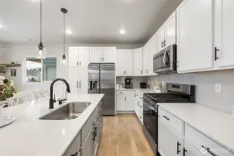 Modern kitchen with gas cooking and designer backsplash.