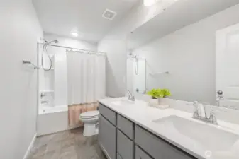 Guest bath with dual vanities, centrally located upstairs.