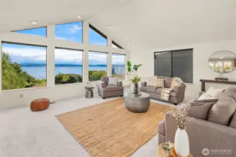The main level living room boasts a vaulted ceiling, a wall of windows, and whale-watching views.