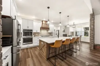 Brick accents, warm wood tones, expansive island & stunning range hood, tile backsplash, Luxury Vinyl Flooring, Butler's Pantry, dining nook, also an adjacent dining room.
