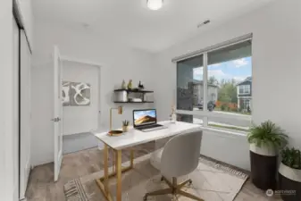 Main level bedroom with ensuite bathroom, virtually staged as a home office