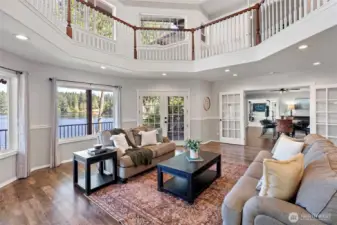 Living area with views of the lake, french doors to the deck and oversided french doors to the dining room beyond.
