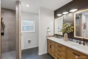 Primary suite bath with walk in shower, dual sinks.