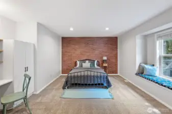 3rd bedroom with brick accent wall and cozy window seat.