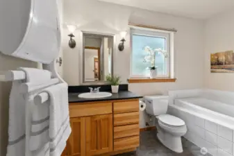 Main floor primary bathroom with shower and soaking tub.