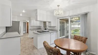Open kitchen with a dining nook and seamless indoor-outdoor flow through the sliding doors.