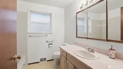 Bright and functional full bathroom with a large mirror and ample counter space.