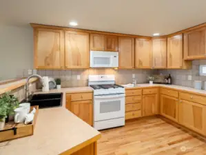 The kitchen is one of the largest you will find in a townhome style home.... notice the gorgeous hardwood floors, abundant storage and counterspace!