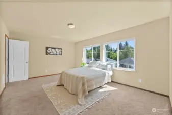 Huge primary bedroom with windows to flood in natural light.