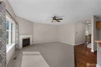 Generous great room feautres a gas fireplace insert and ceiling fan, offering plenty of space for entertaining.