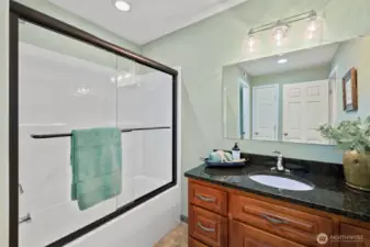 Guest Bath featuring glass doors and granite countertop