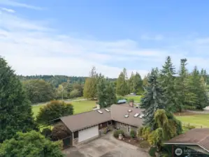 A stunning overhead view showcasing the full home and beautifully landscaped backyard