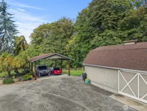 Covered carport plus an additional outbuilding provide plenty of protected parking and extra storage.